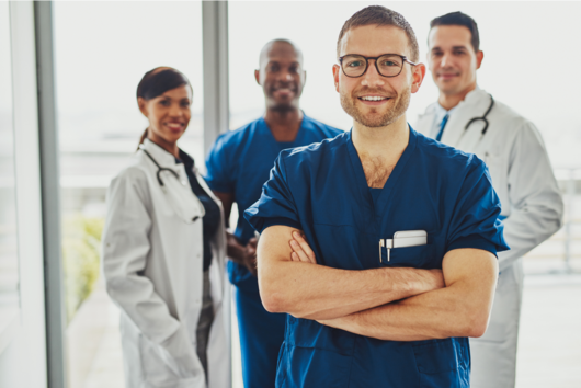 A male doctor standing in front of his colleagues