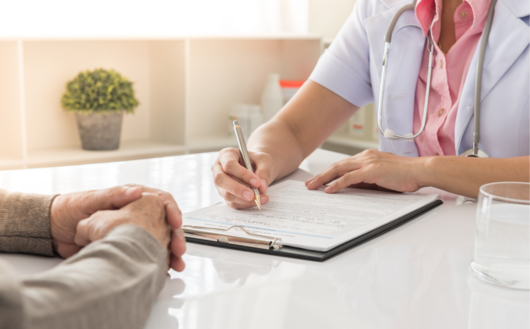 a doctor taking notes on a chart while talking to a patient 