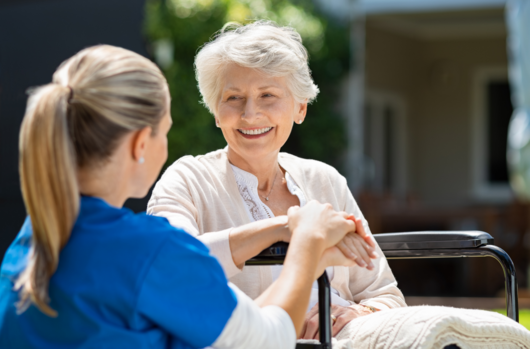 a nurse holding the hand of a patient in a wheel chair